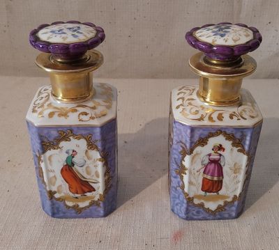 une paire de flacons de parfum violets et dorés ornés d'illustrations représentant des femmes