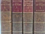 Quatre vieux livres sont alignés sur une table