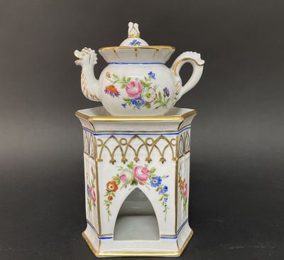un gros plan d'une théière blanche ornée de fleurs