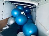 a white van with a bunch of blue balls in the back