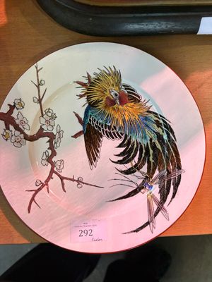 a colorful plate with a bird on it on a table
