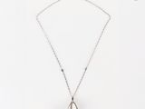 un gros plan sur un collier en argent orné d'un pendentif en forme de larme