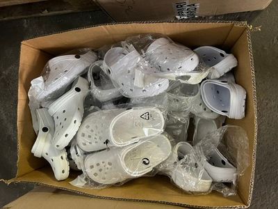 many pairs of shoes in a cardboard box on the floor