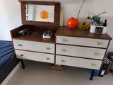 a dresser with a mirror on top of it in a bedroom