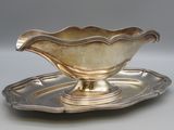 a silver plate with a silver saucer on it