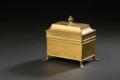 brass box with a lid on a stand on a black background