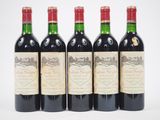 four bottles of wine are lined up on a white surface
