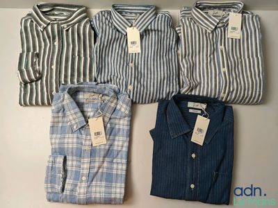 three men ' s shirts are lined up on a shelf