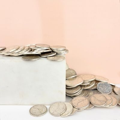 a pile of coins sitting on top of a white box