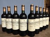 six bottles of wine are lined up on a wooden table