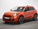 une voiture orange vif garée dans une pièce au sol à carreaux