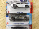 three hot wheels cars are in a package on a table