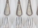 six forks and six spoons on a white table