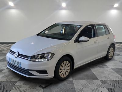 la volkswagen golf blanche est garée dans une pièce au sol en damier
