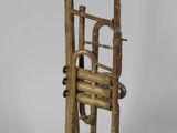 an old brass trumpet sitting on top of a white surface