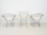 three chairs in a room with a white wall and a white floor