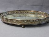 a silver tray with a mirror on it on a table