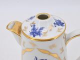 a white and blue tea pot with a gold rim