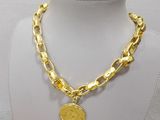 gold plated necklace with a coin on a white mannequin