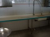 a sink in the middle of a kitchen with a large mirror above it