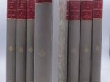 several books are lined up in a row on a white surface
