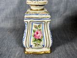an image of a small white and blue vase with a pink rose on it