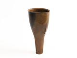 a brown vase that is sitting on a white surface