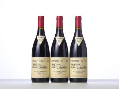 trois bouteilles de vin rouge sont alignées sur une table