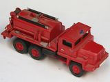 un petit camion rouge posé sur une surface blanche