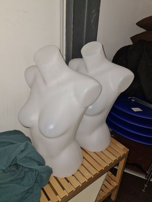 trois mannequins blancs posés sur une étagère en bois