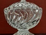 un saladier en verre avec un couvercle posé sur une table