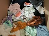 a cardboard box filled with clothes and other items