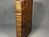 an old book sitting on top of a table next to a gray background