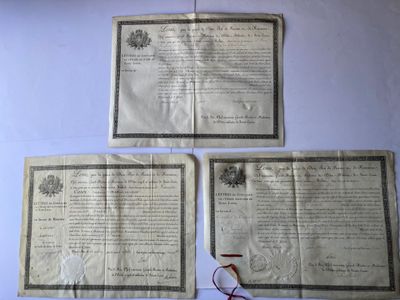 trois vieux journaux sur lesquels sont posés une paire de ciseaux