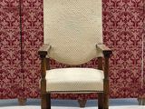 an image of a chair in front of a wall with red and white wallpaper