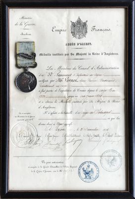 un vieux document sur lequel figure une médaille