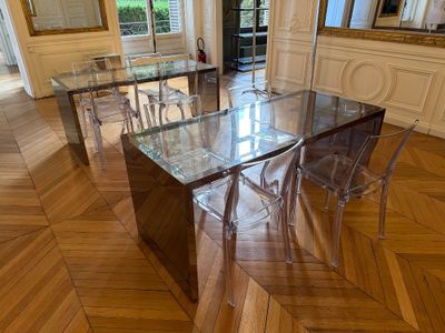 une table et des chaises en verre au milieu d'une pièce