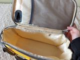 a person holding a piece of luggage on a bed