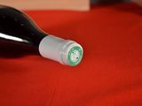 a bottle of wine sitting on a red table cloth