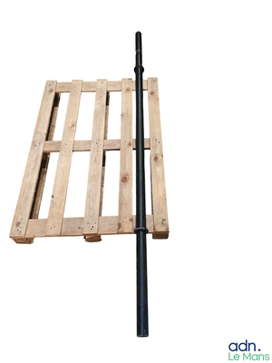 une palette en bois à laquelle est fixé un poteau noir