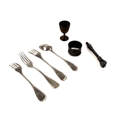 Plusieurs fourchettes, cuillères et une tasse sont posées sur une table.
