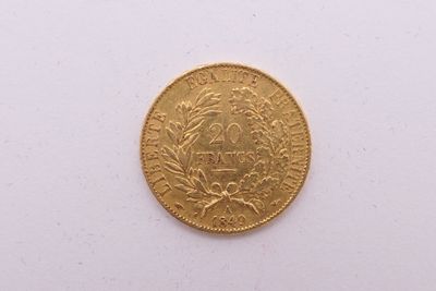 gros plan d'une pièce d'or sur une surface blanche