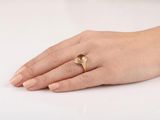 a woman ' s hand with a gold ring on it