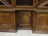 two wooden cabinets with glass doors and a red curtain behind them