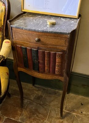 une chaise et une table dans une pièce où il y a un tableau accroché au mur