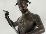 a bronze statue of a man holding a baseball bat