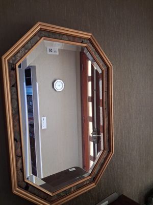 un miroir sur le mur au-dessus d'un lavabo dans une salle de bains