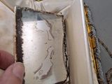 a hand that is holding a box with a picture inside of it