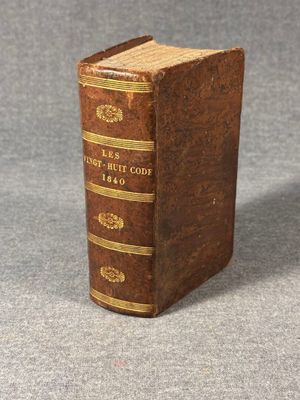 an old book sitting on top of a table on a gray surface