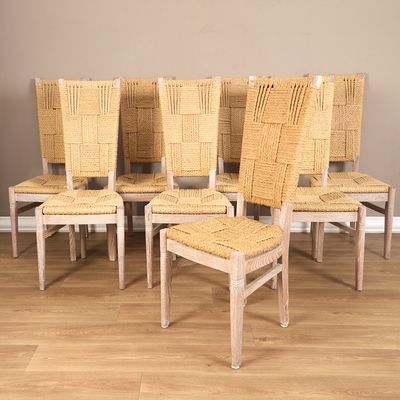 six chairs with woven seats sit in a row on a hard wood floor